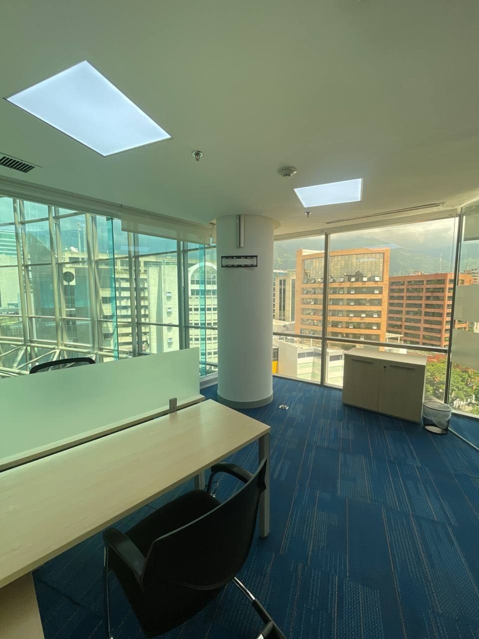 Oficina privada luminosa con ventanales en Spatium Caracas